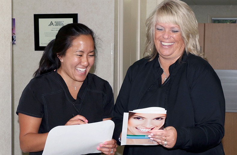 Two Norton Shores dental team members laughing together